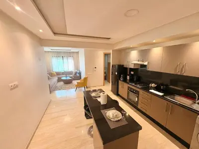 a large kitchen with a table in a room at cozy furnished studio fully equipped in Casablanca