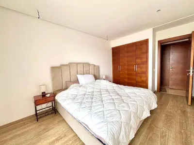 a bedroom with a large white bed and a wooden floor at La perla del Atlántico in Casablanca