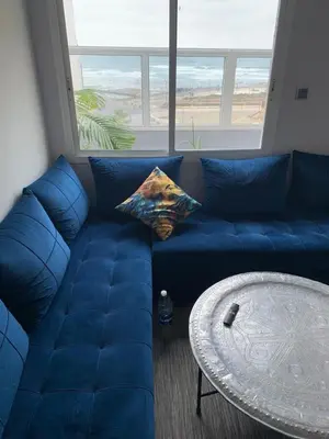 a blue couch in a living room with a table at Studio Corniche Casablanca in Casablanca