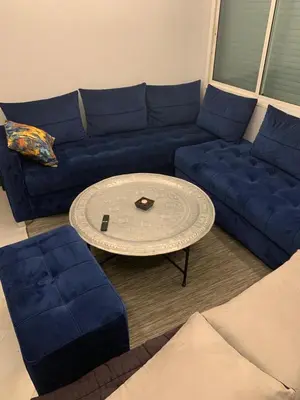 a living room with a blue couch and a table at Studio Corniche Casablanca in Casablanca