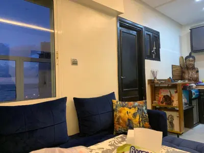 a living room with a blue couch and a window at Studio Corniche Casablanca in Casablanca