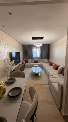 a living room with a couch and a table at Flat in Sidi Rahal Chatai with Ocean View in Sidi Rahal