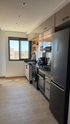 a kitchen with a refrigerator and a stove top oven at Flat in Sidi Rahal Chatai with Ocean View in Sidi Rahal