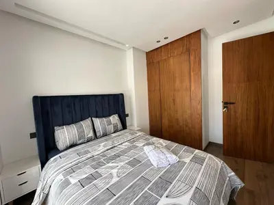 a bedroom with a bed and a wooden door at appartement les princesses 2chmbr salon 2 terasse in Maarif