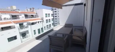 a balcony with a table and chairs on a building at appartement les princesses 2chmbr salon 2 terasse in Maarif