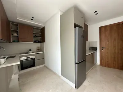 a kitchen with a stainless steel refrigerator and wooden cabinets at appartement les princesses 2chmbr salon 2 terasse in Maarif
