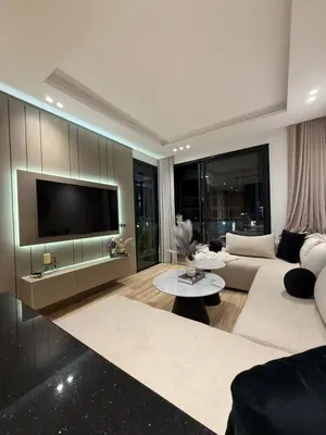 a living room with a couch and a flat screen tv at Appartement Haut Standing vue Piscine in Sidi Rahal