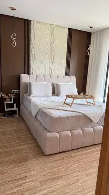 a large bedroom with a large bed with a table on it at Appartement Haut Standing vue Piscine in Sidi Rahal