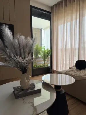 a living room with a table and a couch at Appartement Haut Standing vue Piscine in Sidi Rahal
