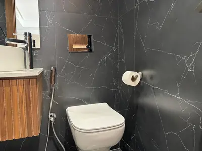 a bathroom with a white toilet and a black wall at Modern Studio Princesses District in Maarif
