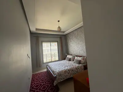 a small bedroom with a bed and a window at Appartement Residence Mansbay - Piscine - Accès Plage - WIFI in Mohammedia