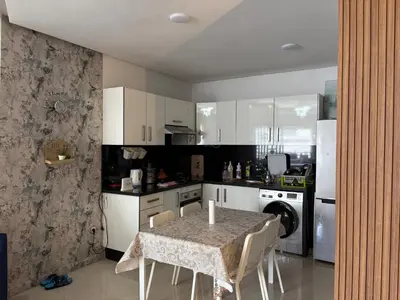a kitchen with a table with chairs and a refrigerator at Appartement Residence Mansbay - Piscine - Accès Plage - WIFI in Mohammedia