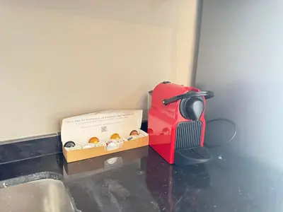 a box of donuts and a juicer next to a sink at Élégant Studio Neuf Quartier 2 Mars Sécurisé in Aïn Chock