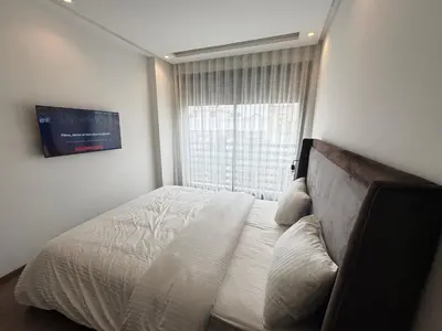 a bedroom with a bed with a large window at Élégant Studio Neuf Quartier 2 Mars Sécurisé in Aïn Chock