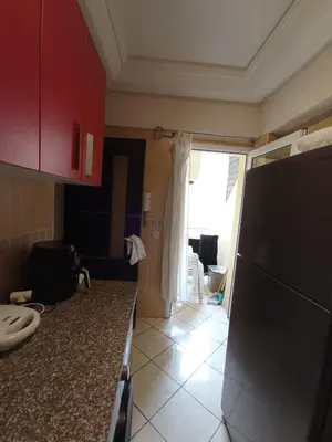 a kitchen with red cabinets and a counter top at SUMMER AND FAMILY APPARTEMMENT ,mouhamadia in Mohammedia