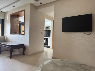 a living room with a flat screen tv on a wall at Les perles de tamaris in Casablanca