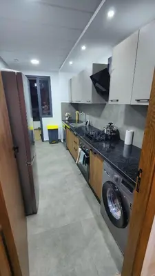a kitchen with a stainless steel refrigerator and a stove at Appartement de prestige à Dar bouazza avec plusieurs piscines et à proximité à la plage in Tamaris