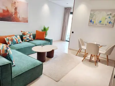 a living room with a couch and a table at Studio Confortable et Cozy 5 min du stade CAN2025- Maarif Casablanca in Casablanca
