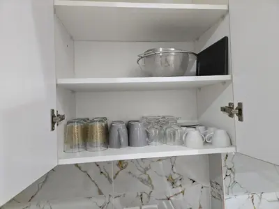 a shelf with glass jars and a bowl on it at Appart Bouznika neuf in Bouznika