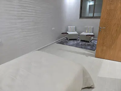 a white room with two chairs and a bed at Appart Bouznika neuf in Bouznika