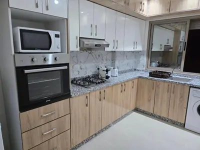 a kitchen with a stove and a microwave at Appart Bouznika neuf in Bouznika