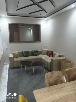 a living room with a couch and two tables at Appart Bouznika neuf in Bouznika