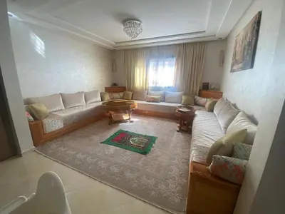 a living room with a couch and a table at Beach apartment in Bouznika