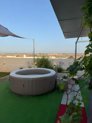 a circular fire pit sitting on a green lawn at 322 Costa beach , Bouznika in Bouznika