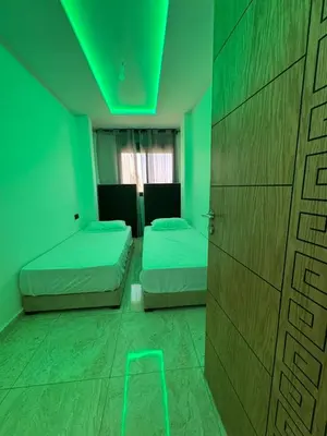a room with two beds and a green light at 322 Costa beach , Bouznika in Bouznika