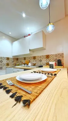 a kitchen with a table with plates and feathers on it at Cosy studio Steps to Shore and Tramway in Rabat