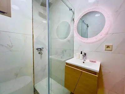 a bathroom with a shower and a sink and a mirror at Cosy studio Steps to Shore and Tramway in Rabat