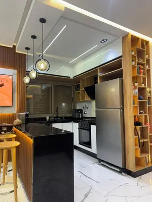 a kitchen with a stainless steel refrigerator and cabinets at Cozy studio in Bouznika