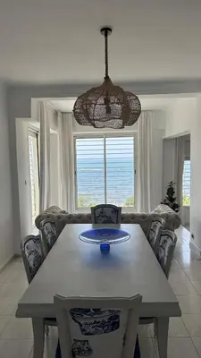 a dining table and chairs in a living room at Dar Alyakoute - Harhoura in Temara