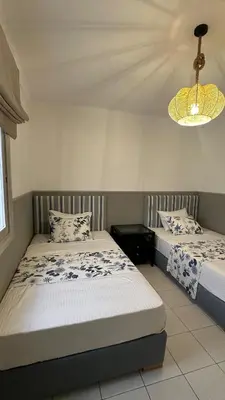 a bedroom with two beds and a chandelier at Dar Alyakoute - Harhoura in Temara