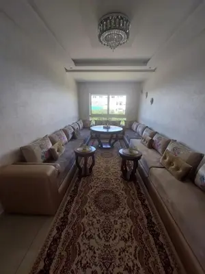a living room with a couch and a table at Appartement lux a mansoria les terrasses 2 et 3 in Mansouria