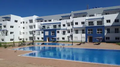 a large building with a swimming pool in front of it at Appartement lux a mansoria les terrasses 2 et 3 in Mansouria