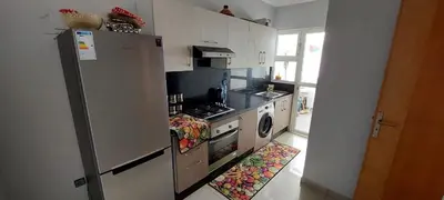 a kitchen with a refrigerator and a stove top oven at Appartement lux a mansoria les terrasses 2 et 3 in Mansouria