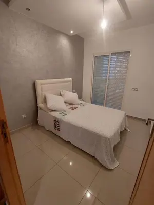 a bedroom with a bed and a window in it at Appartement lux a mansoria les terrasses 2 et 3 in Mansouria