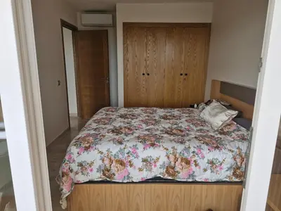 a bedroom with a bed with a floral comforter at Bel appartement pour location in O Ben Slimane
