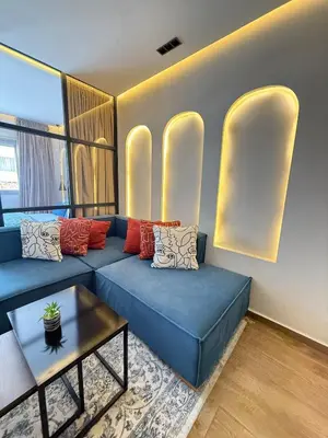 a living room with a blue couch and a table at New apartment in the heart of Rabat in Rabat