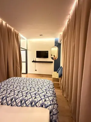 a bedroom with a bed with curtains and a television at New apartment in the heart of Rabat in Rabat