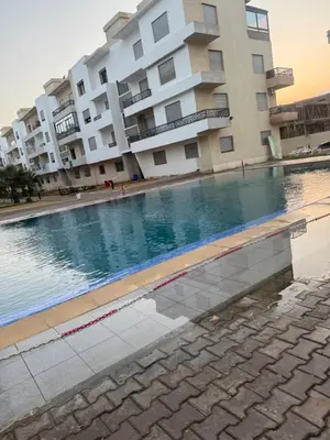 a swimming pool in front of a building at Residence sables dor Mohammedia in Mohammedia