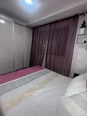 a small bedroom with a bed and a curtain at Residence sables dor Mohammedia in Mohammedia