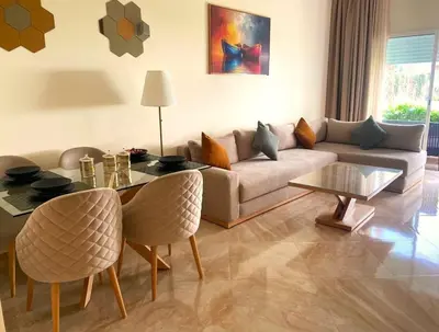 a living room with a couch and a table at Bouznika Apartement de luxe 2 Chambres RDC in Bouznika