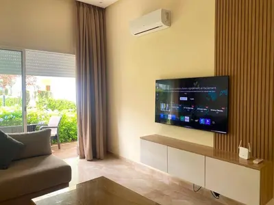 a living room with a flat screen tv on the wall at Bouznika Apartement de luxe 2 Chambres RDC in Bouznika