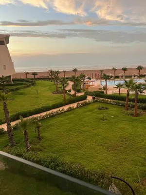 a view of a park with palm trees and a building at La perle de Sidi by Rachid in Dar Oulad Hajj Kassem