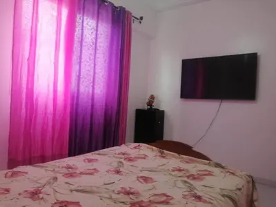 a bedroom with a bed with purple curtains and a tv at Hatime zarkaoui in Casablanca