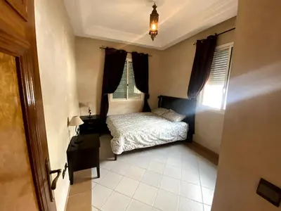 a small bedroom with a bed and a window at Appartement a louer a mansouria rico flores in O Ben Slimane