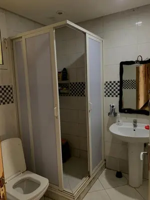 a bathroom with a shower and a toilet and a sink at Résidence sara in Casablanca