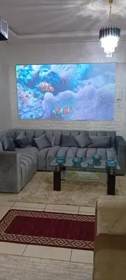 a living room with a couch and a large painting at Modern and comfortable apartment in mohammedia in Ben Yakhlef